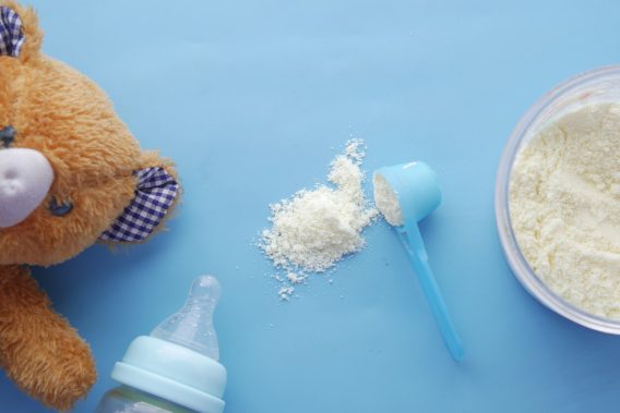 Bear, bottle and baby formula on blue background