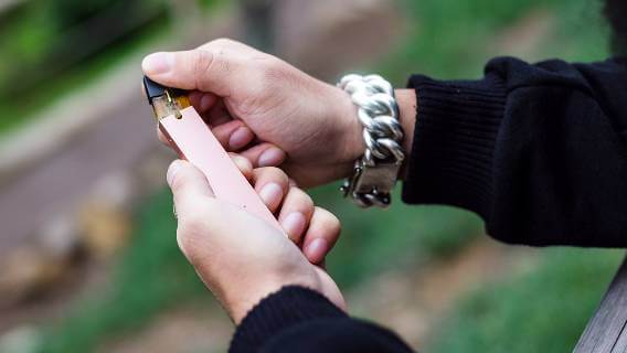 Man loading cartridge on e-cigarette