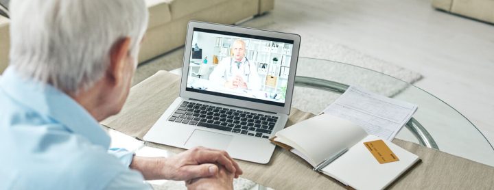 Elderly man using laptop for telemedicine visit with doctor