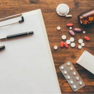 clipboard and pills on top of a table