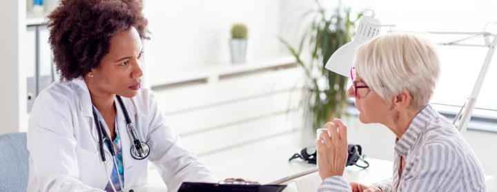 Woman speaking with doctor at her desk