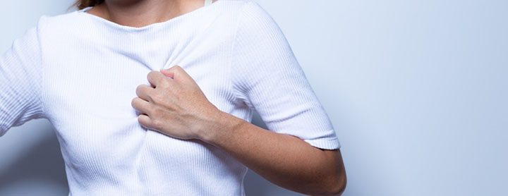Woman clutches her chest in pain