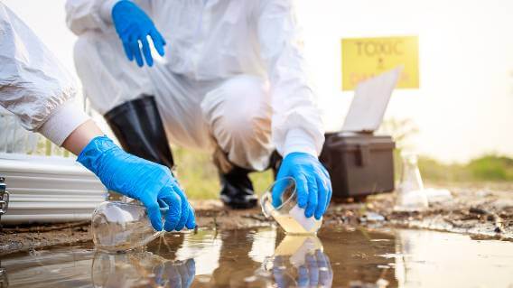 Workers in hazmat suits testing water